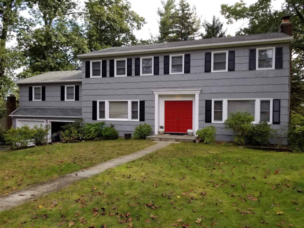 gray house with black shutters and red front door