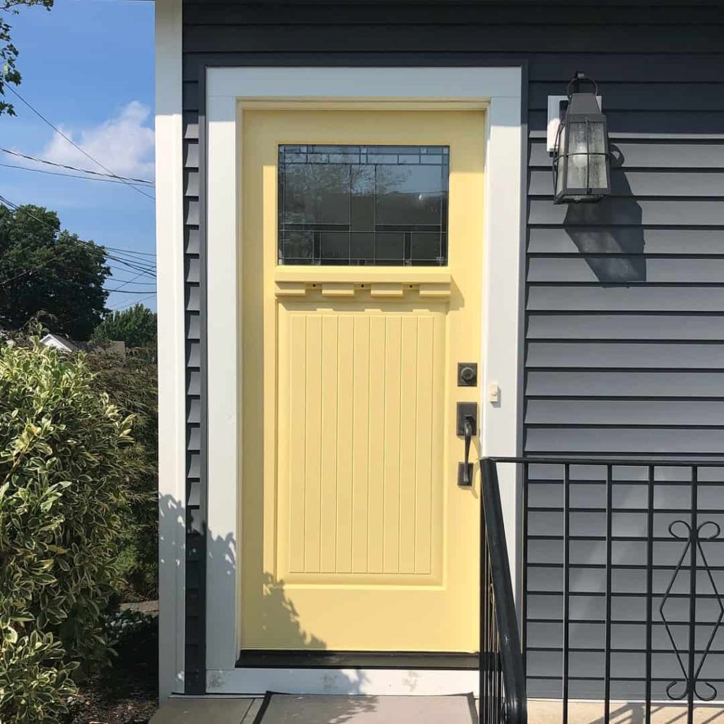 Yellow front door on a gray home