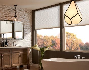 bathroom with large windows and free standing tub
