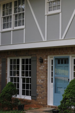 gray and brick exterior with blue front door