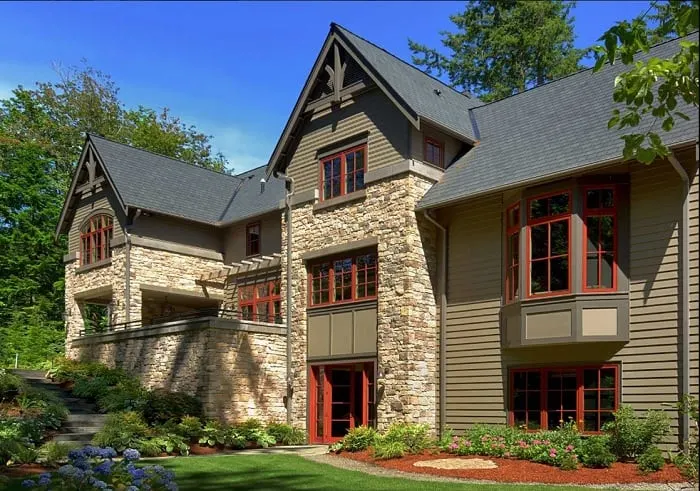 Three story home wih taupe, brick and siding and accents of red