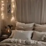 bedroom with a bed with pillows and soft lighting above the bed