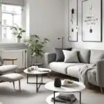 small living room with gray couch and chair two small round coffee tables and simple wall art (1)