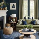 Living room with navy blue walls, round wood coffee table, sage green curtains and couch