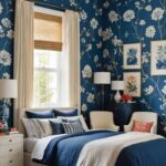 bedroom with bed, night stand , chairs and blue floral wallpaper on the walls