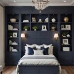 _guest bedroom with bed, navy blue built ins behind the bed and crystal chandelier