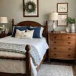 vintage style guest bedroom with bed, night stand, picture above the bed and wood dresser