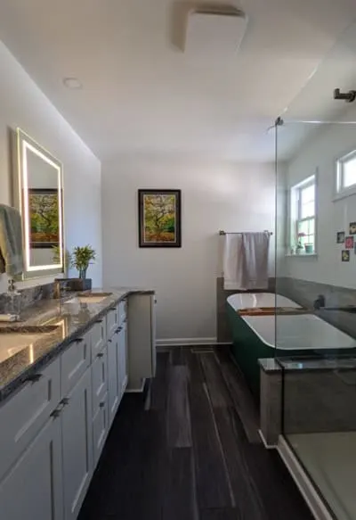 Bathroom with glass shower, double vanity and white walls