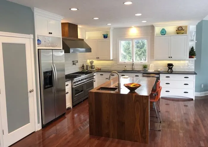 Large kitchen with white cabinets, Decorator's White painted walls and island