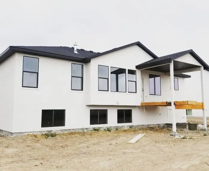 Exterior of a large home with black roof and light gray siding