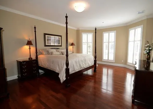 Shaker Beige painted walls in lrage master bedroom with four post bed and red wood floors