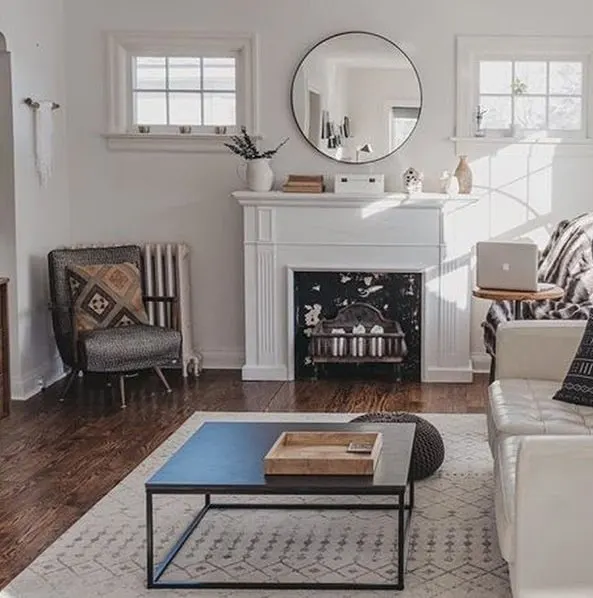 living room with fire place, round mirror and Eider White Walls