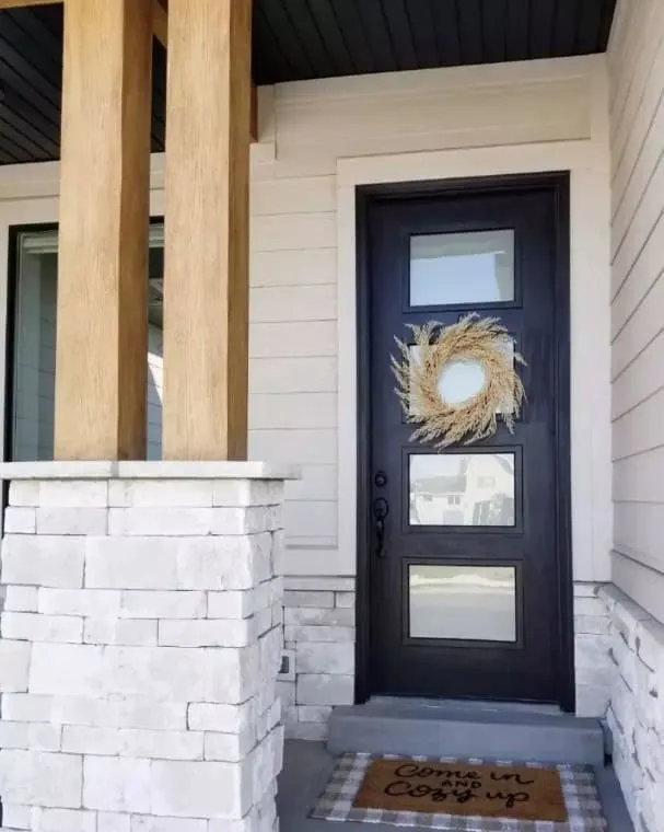 porch exterior with black door and wreath