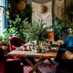 A boho style dining room decorated for Christmas with plants, a table and vibrant colored chairs