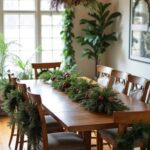 A modern farmhouse dining room decorated for Christmas with dining room chairs with mini wreaths on the backs of the chairs