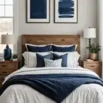 A neutral room with a bed, wood nightstands and window, with navy blue accents