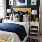 Bedroom with a navy blue and gold color palette , with a bed, nightstands and window