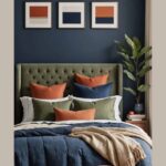 Bedroom with bed, navy blue wall, art on the wall and earthy colors