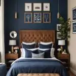 Bedroom with navy blue accent wall, brown tufted head board on bed with navy blue bedding and art on the walls