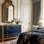 bedroom with ornate wall mirror over a navy blue dresser and bed.