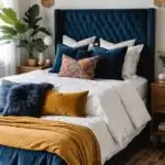 boho bedroom neutral walls, bed with navy blue headboart and a plant