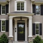 A Taupe house with white trim, dark shutters, and natural stone accents.