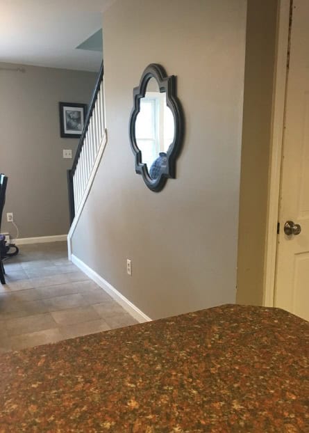 room with taupe colored walls and a mirror hanging on the wall