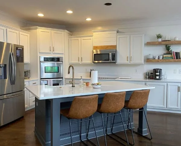 white kitchen cabinets with a dark painted island