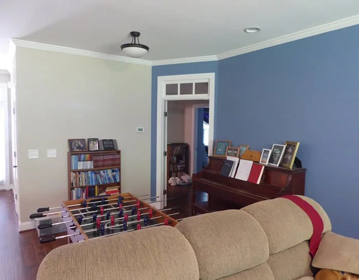 living room with two-toned walls, couch and game table